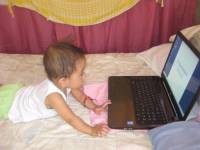 cute lil baby busy watching on the laptop