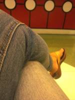 legs crossed jeans brown sandals waiting be likw