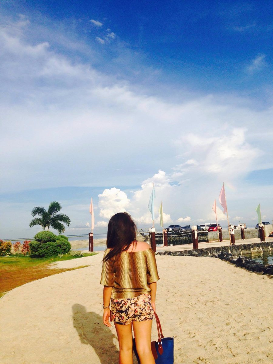 pretty lady back view sexy at solea blue bag nice outfit walking on the sands