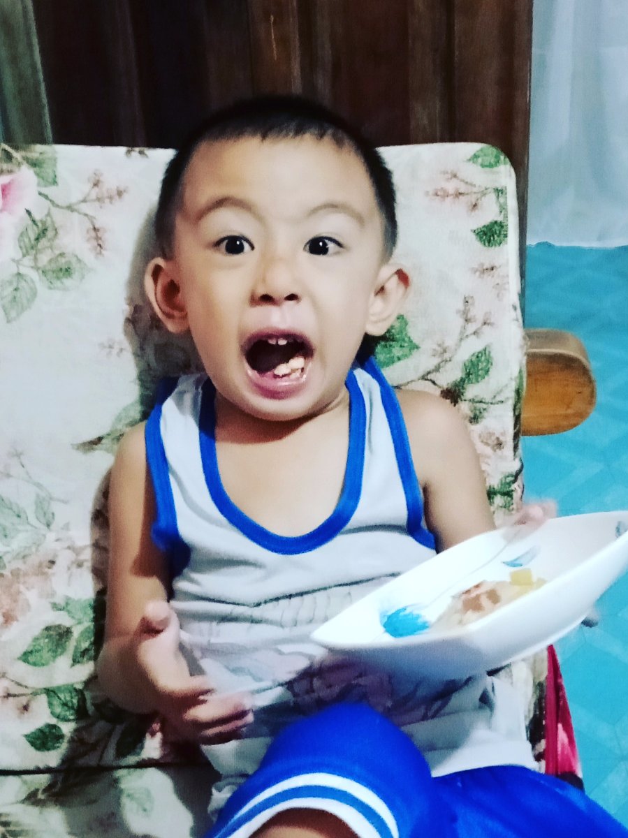 Cute little gaven mouth wide open eating pizza